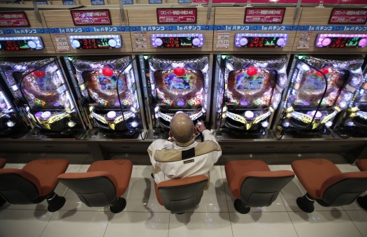 A visitor plays Pachinko, a Japanese form of legal gambling, at Dynam Japan Holdings Co.'s Pachinko parlour in Koga